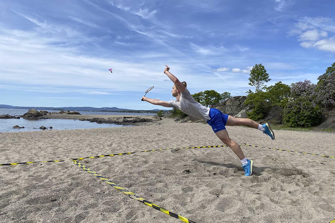 En gutt som spiller badminton utendørs med en Airbadmintonball