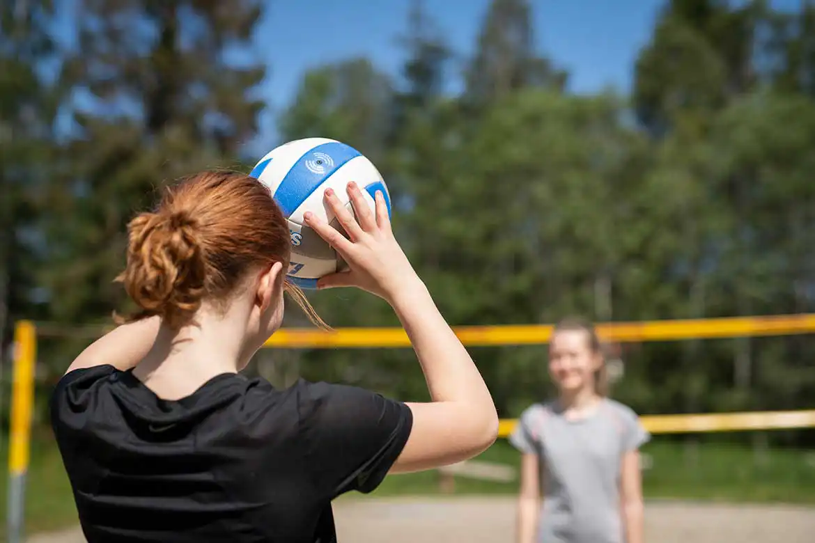 To unge jenter som spiller sandvolleyball